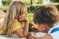 Outdoors closeup image of happy children playing on the blanket outdoors. Rear view of little boy and cute little girl having fun Royalty Free Stock Photo