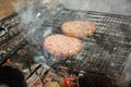 Outdoors cooking burgers on hot grill with flames Royalty Free Stock Photo