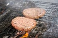 Outdoors cooking burgers on hot grill with flames Royalty Free Stock Photo