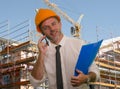 Corporate portrait of young attractive and successful engineer man or architect working on building at construction site wearing Royalty Free Stock Photo