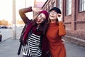 Outdoors fashion portrait young pretty best girls friends in friendly hug. Walking at the city. Posing at the street Royalty Free Stock Photo