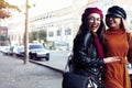 Outdoors fashion portrait young pretty best girls friends in friendly hug. Walking at the city. Posing at the street Royalty Free Stock Photo