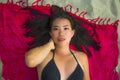 Outdoors fresh and natural portrait of young beautiful and happy Asian Cchinese woman in bikini lying flat on sarong on beach sand Royalty Free Stock Photo