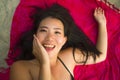 Outdoors fresh and natural portrait of young beautiful and happy Asian Cchinese woman in bikini lying flat on sarong on beach sand Royalty Free Stock Photo