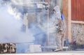 Outdoors healthcare worker spraying chemical to eliminate mosquitoes at abandoned house in suburb residential area