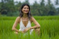 Outdoors holidays portrait of middle aged attractive and elegant Asian woman in white dress enjoying beauty of nature at tropical