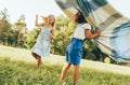 Outdoors image of children playing under the blanket, jumping and dancing together. Happy little boy and little girl enjoying Royalty Free Stock Photo