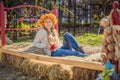 Outdoors lifestyle close up portrait of charming blonde young woman wearing a wreath of autumn leaves. Wearing stylish