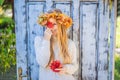 Outdoors lifestyle close up portrait of charming blonde young woman wearing a wreath of autumn leaves. Wearing stylish