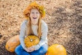 Outdoors lifestyle fashion image of happy beautiful girl sitting in autumn park. Holding a pumpkin. Wearing stylish Royalty Free Stock Photo