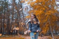 Outdoors lifestyle fashion image of happy beautiful girl throwing leaves up in the air in autumn park Royalty Free Stock Photo