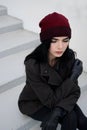 Outdoors lifestyle fashion portrait of Beautiful brunette woman wearing warm winter autumn clothes and knitted hat. Royalty Free Stock Photo