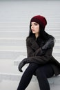 Outdoors lifestyle fashion portrait of Beautiful brunette woman wearing warm winter autumn clothes and knitted hat Royalty Free Stock Photo