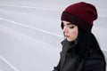 Outdoors lifestyle fashion portrait of Beautiful brunette woman wearing warm winter autumn clothes and knitted hat. Royalty Free Stock Photo