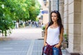 Outdoors lifestyle fashion portrait of contented young woman sitting outdoors.