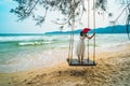 Outdoors lifestyle fashion portrait stunning young girl enjoying on swing on the tropical island. In background the sea. Wearing Royalty Free Stock Photo