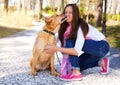 Outdoors lifestyle portrait of beautiful girl with a cute dog on