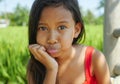 Outdoors lifestyle portrait of beautiful and sweet young girl happy posing doing playful faces, the child dressed in a red dress Royalty Free Stock Photo