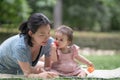 outdoors lifestyle portrait of mother and daughter - young happy and sweet Asian Chinese woman playing with her 8 months baby girl Royalty Free Stock Photo