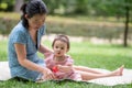 outdoors lifestyle portrait of mother and daughter - young happy and sweet Asian Korean woman playing with her 8 months baby girl Royalty Free Stock Photo