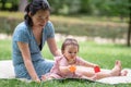 outdoors lifestyle portrait of mother and daughter - young happy and sweet Asian Korean woman playing with her 8 months baby girl Royalty Free Stock Photo