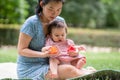 outdoors lifestyle portrait of mother and daughter - young happy and sweet Asian Korean woman playing with her 8 months baby girl Royalty Free Stock Photo