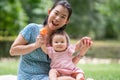 outdoors lifestyle portrait of mother and daughter - young happy and sweet Asian Korean woman playing with her 8 months baby girl Royalty Free Stock Photo