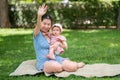 outdoors lifestyle portrait of mother and daughter - young happy and sweet Asian Korean woman playing with her 8 months baby girl Royalty Free Stock Photo