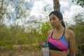 Outdoors lifestyle portrait of young attractive tired and thirsty Asian woman drinking water after hard running workout cooling Royalty Free Stock Photo