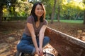 Outdoors lifestyle portrait of young happy and beautiful Asian Chinese woman enjoying relaxed and cheerful at sitting on city park Royalty Free Stock Photo