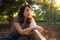 Outdoors lifestyle portrait of young happy and beautiful Asian Korean woman relaxed and thoughtful at sitting pensive on city park Royalty Free Stock Photo