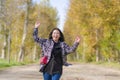 Outdoors lifestyle portrait of young happy and pretty Asian Chinese woman jumping carefree and cheerful at beautiful city park in Royalty Free Stock Photo