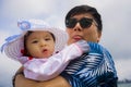 Outdoors lifestyle portrait of young happy and proud Asian Korean man as loving father holding adorable daughter baby girl during Royalty Free Stock Photo