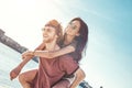 Outdoors photo of happy boyfriends piggybacking their girlfriends at sunset on beach Royalty Free Stock Photo