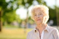 Outdoors portrait of beautiful smiling senior woman with curly white hair Royalty Free Stock Photo