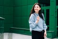 Outdoors portrait of beautiful young brunette girl smiling. Teenager hipster girl with sunglasses wearing trendy outfit posing in Royalty Free Stock Photo