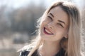 Outdoors portrait of beautiful young brunette girl. Woman smiling happy on sunny summer or spring day outside on city background. Royalty Free Stock Photo