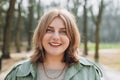 Outdoors portrait of beautiful young woman laughing. 30s cheerful woman tourist dressed in casual look resting outdoors Royalty Free Stock Photo