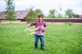 Outdoors portrait of cute preschool boy blowing soap bubbles on a green lawn at the playground Royalty Free Stock Photo