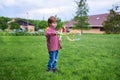 Outdoors portrait of cute preschool boy blowing soap bubbles on a green lawn at the playground Royalty Free Stock Photo