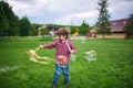 Outdoors portrait of cute preschool boy blowing soap bubbles on a green lawn at the playground Royalty Free Stock Photo