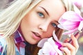 Outdoors portrait of cutie young blonde woman with pink flowers