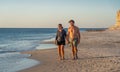 Happy active and healthy mature couple walking on the beach enjoying outdoors lifestyle Royalty Free Stock Photo