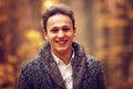 Outdoors portrait of happy young man standing in autumn park at Royalty Free Stock Photo