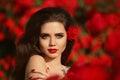 Outdoors portrait of Natural Beauty woman in red roses. Sensual Royalty Free Stock Photo