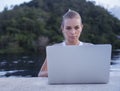 Outdoors portrait of pretty blonde woman with laptop computer Royalty Free Stock Photo