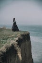 Outdoors portrait of a victorian lady in black standing on the cliff Royalty Free Stock Photo