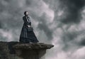 Outdoors portrait of a victorian lady in black standing on the cliff Royalty Free Stock Photo