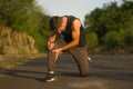 Outdoors portrait of young attractive sport man in pain touching his knee suffering ligaments accident or some injury during Royalty Free Stock Photo