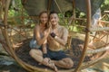 Outdoors portrait of young beautiful and happy couple practicing yoga workout together at tropical forest gazebo smiling cheerful Royalty Free Stock Photo